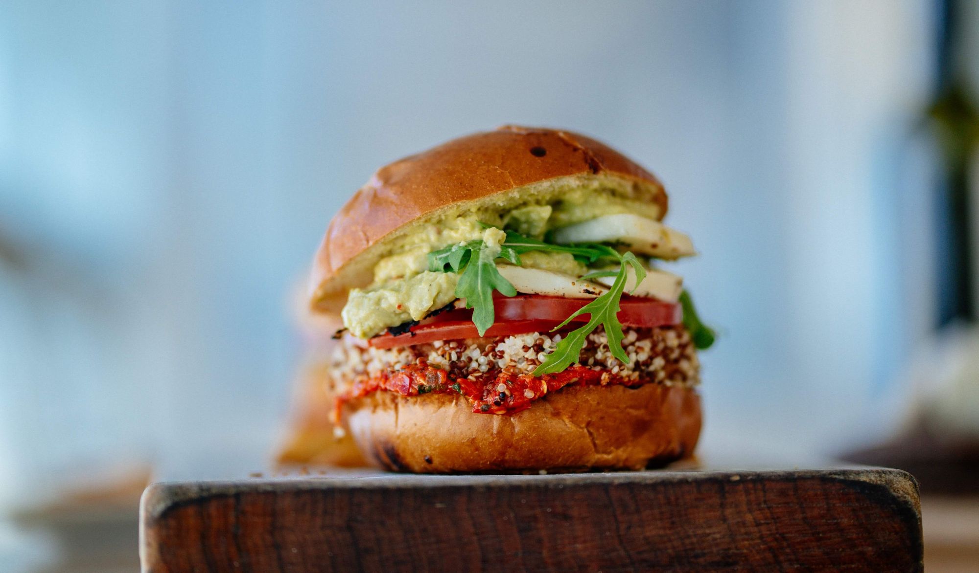 Veggie burger with salad served on a wooden chopping block