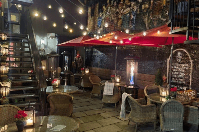 Guy Fawkes Inn courtyard at night with tables, chairs, umbrellas and fairy lights