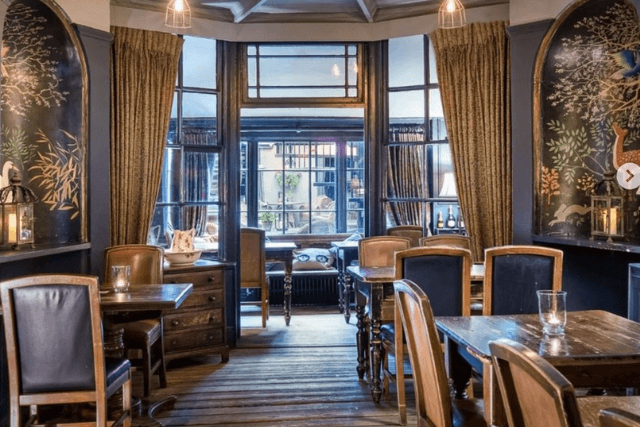 Dining room with wooden floors, wall paintings and paned windows