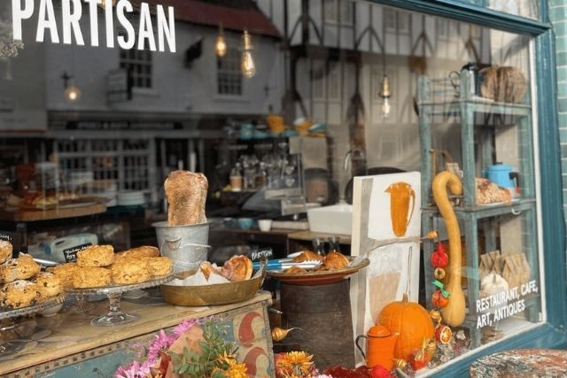 The window display at Partisan in York, with scones, bread, art and flowers