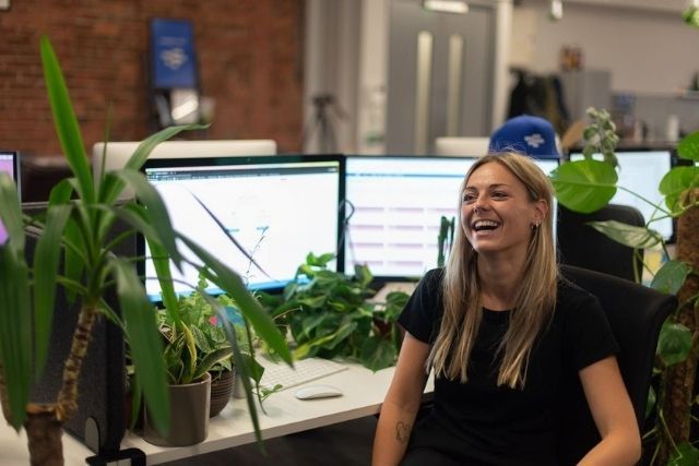 Inside the RotaCloud office in York — a woman with blonde hair laughing, surrounded by plants