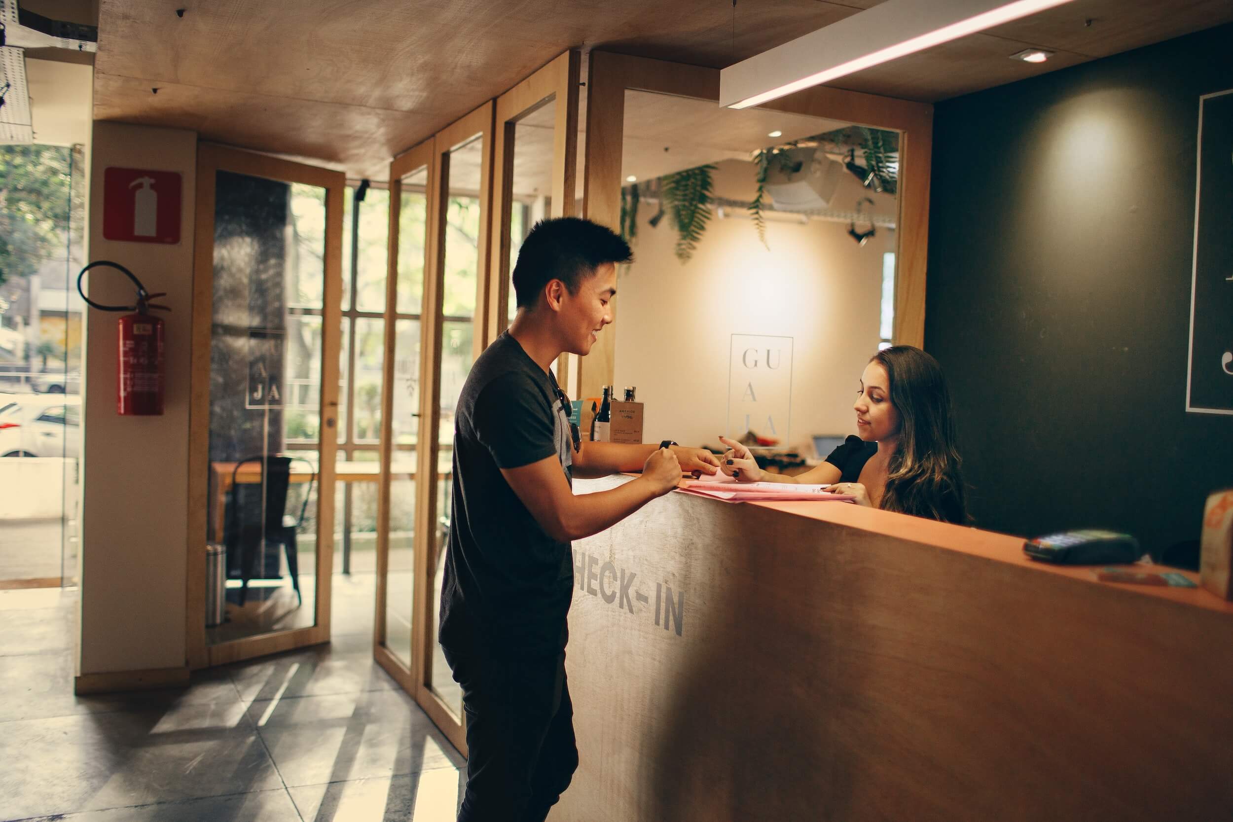 Man checking in at hotel reception desk.