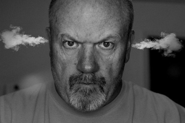 An annoyed man with steam coming out of his ears, in black and white