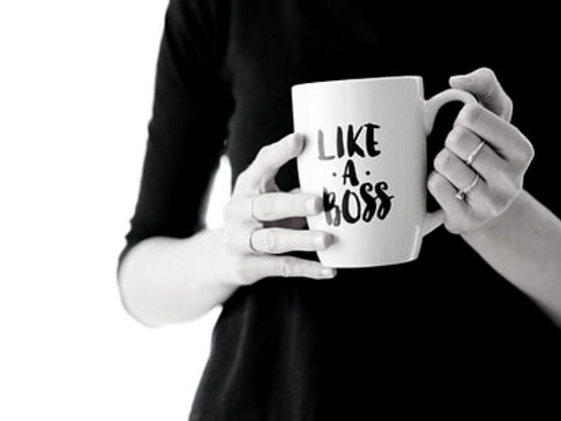 Woman's hands holding a white mug that has 'Like a boss' written on the front