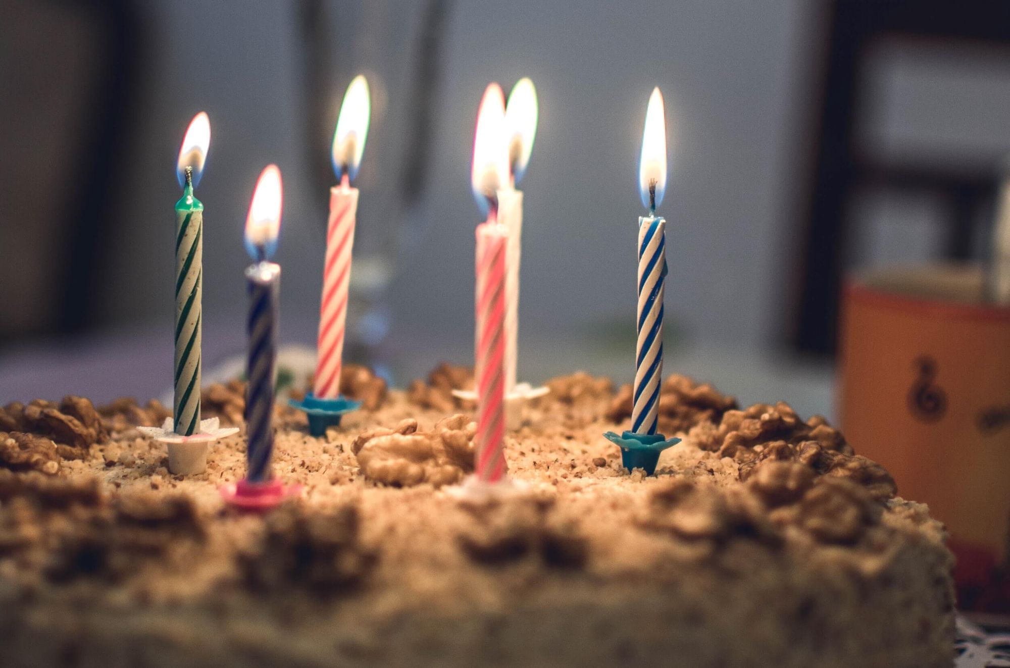 Close-up photo of a cake with six lit birthday candles.