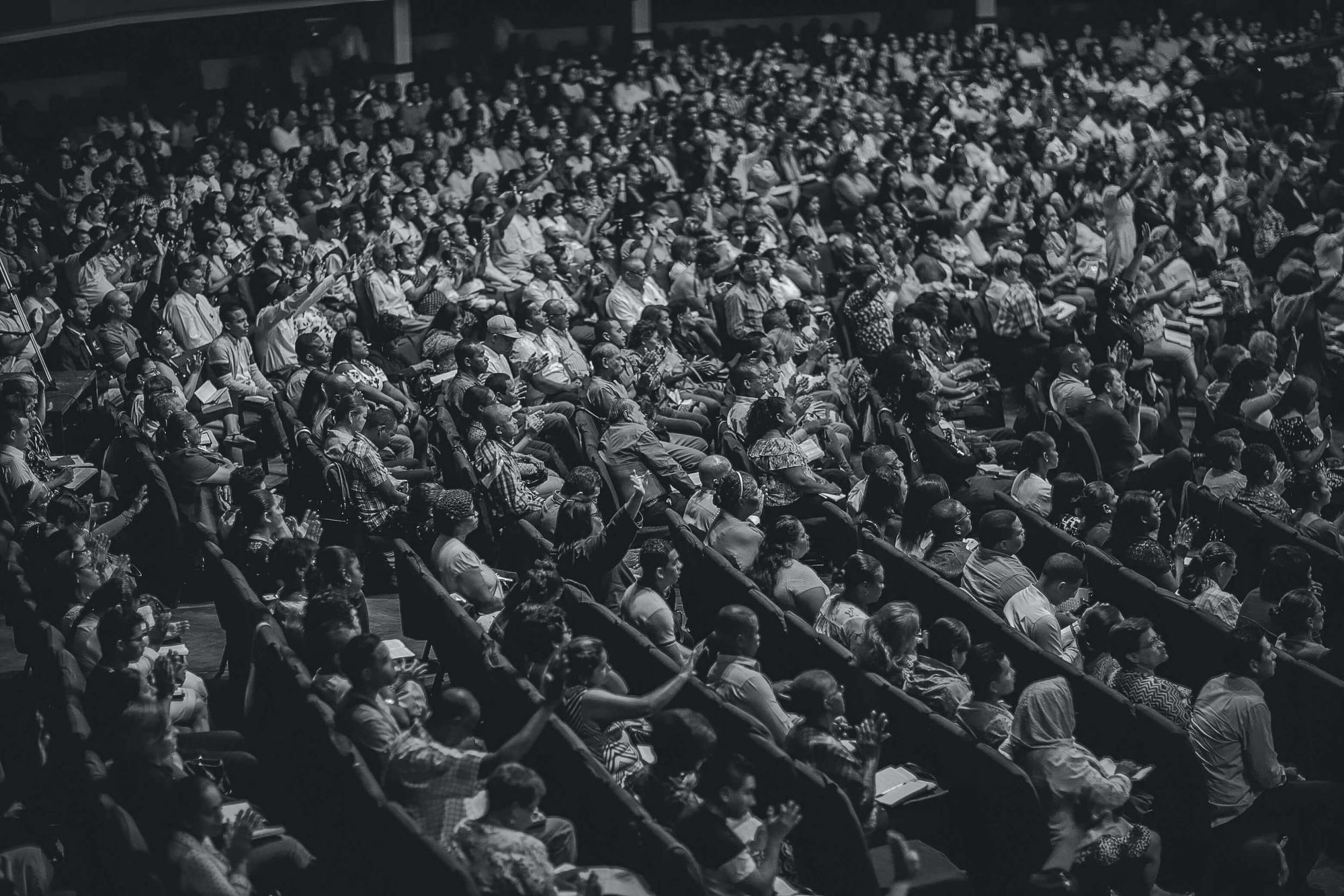 Black-and-white photo of large group of people seated in an auditorium.