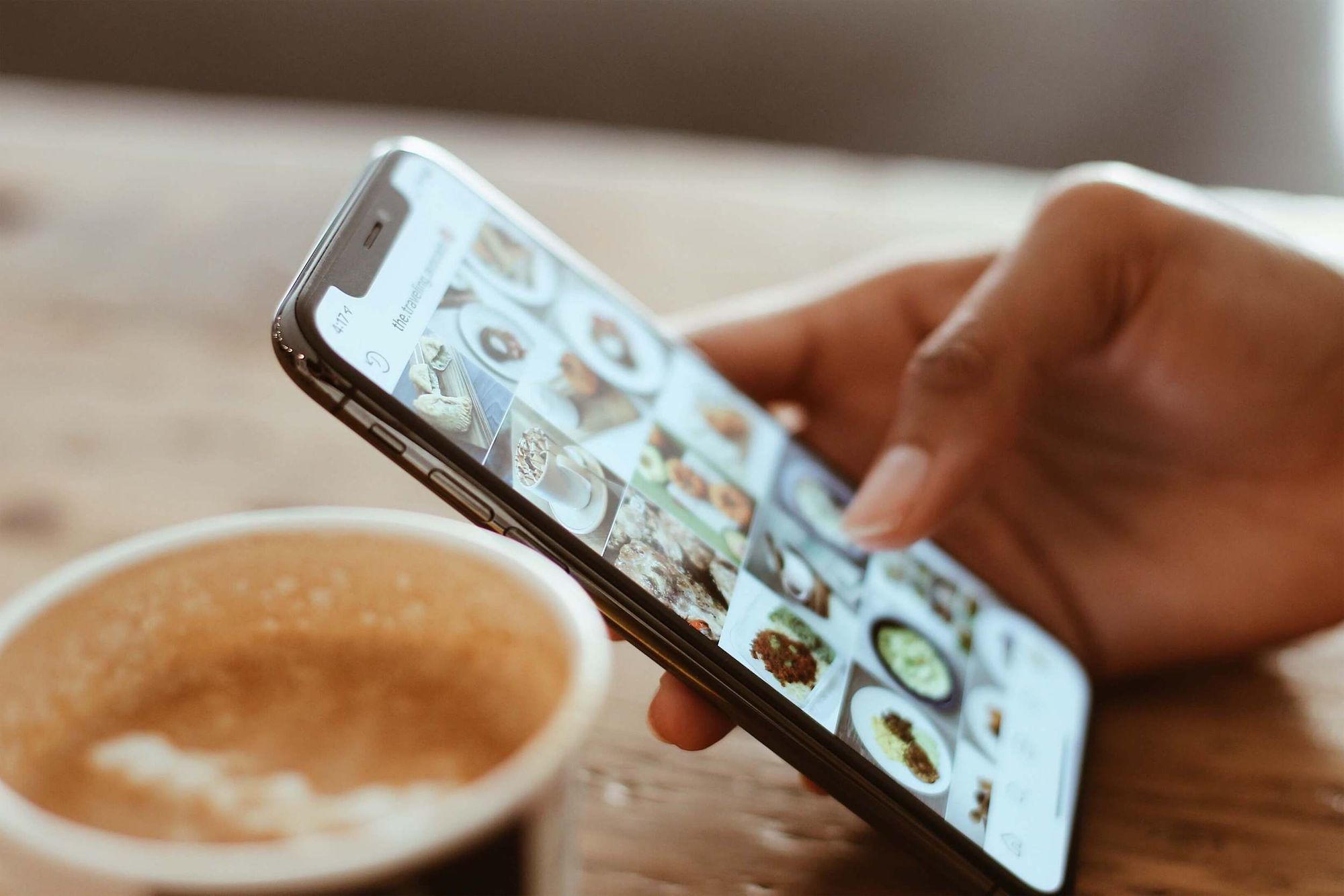 Close-up shot of a hand using a mobile phone running Instagram.