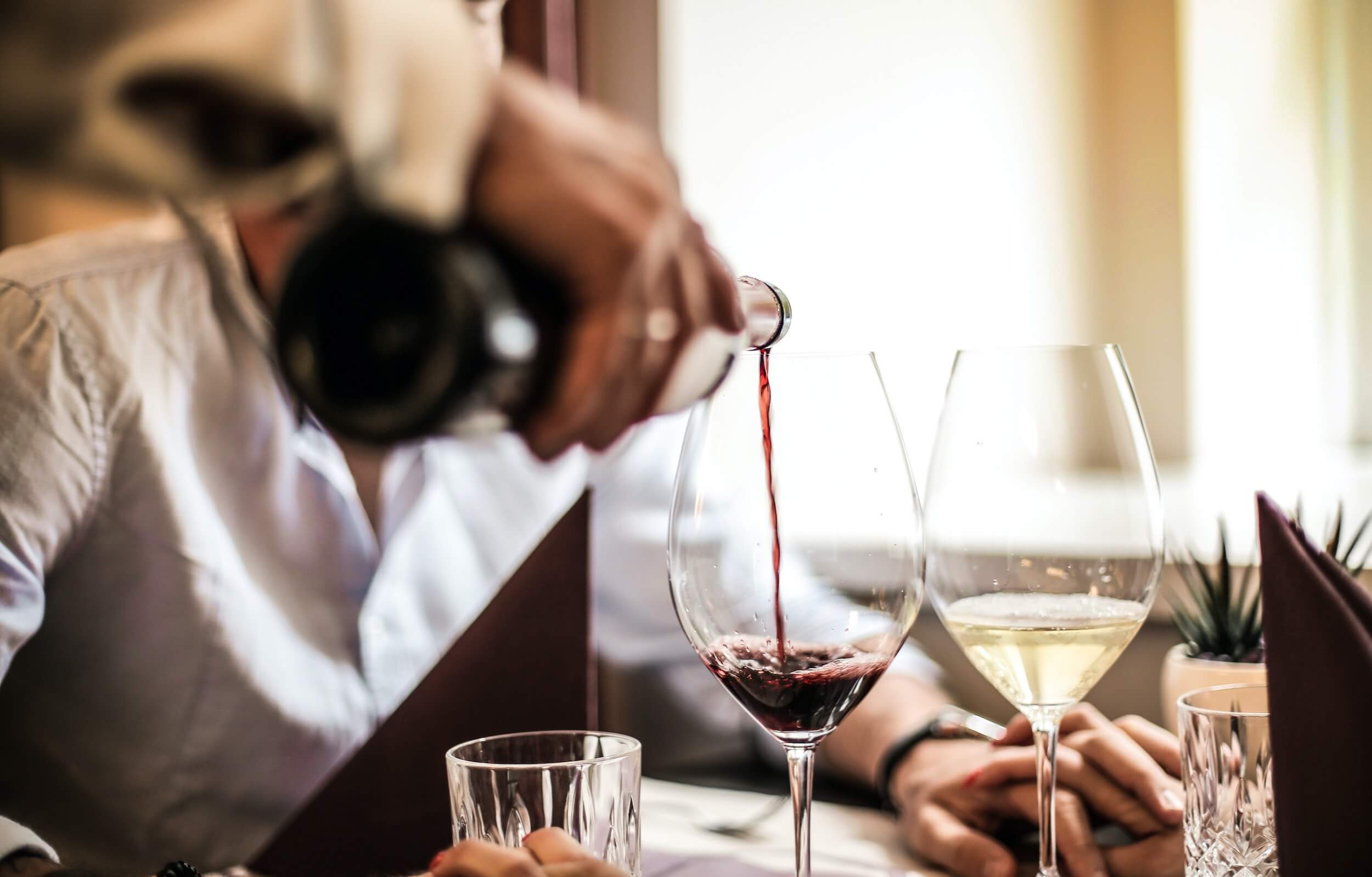 Close up photo of red wine being poured into a wine glass.