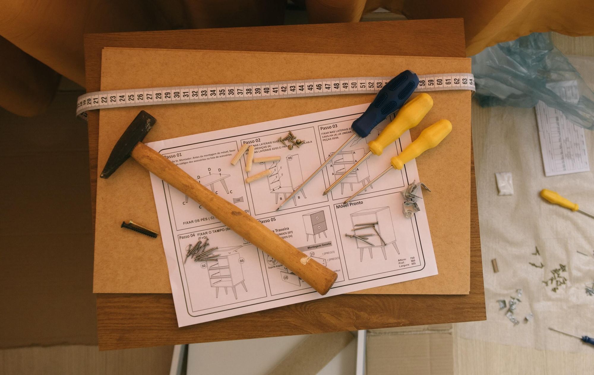 Flat-pack furniture instruction sheet on a box surrounded by tools