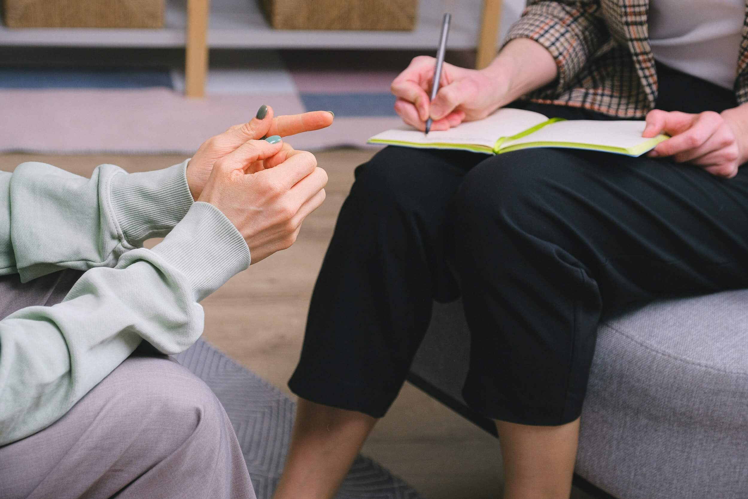 Close-up photo of two people's laps and hands during an interview.