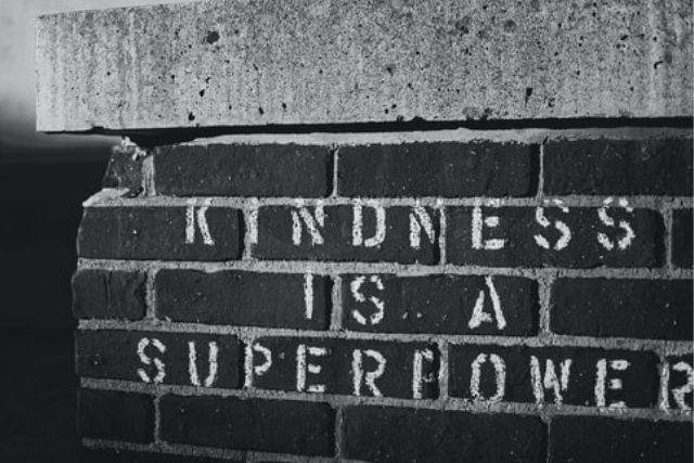 'Kindness is a superpower' stencilled onto bricks (in black and white)